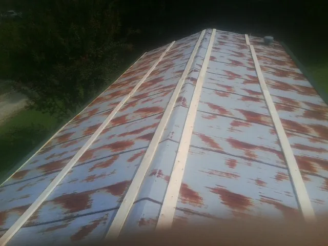 Rusted metal roof panels with new wood purlins before replacement — Storm Damage Roof Repair in Sheridan by Roofing Brothers